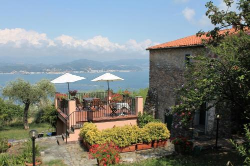 a house with a balcony with a table and umbrella at Terrazza sul Golfo in La Spezia