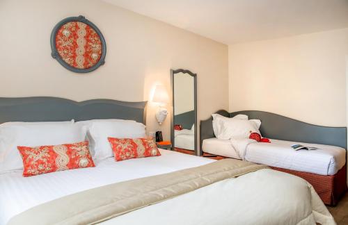 a hotel room with two beds and a mirror at Relais des Trois Châteaux Hôtel-Restaurant - Teritoria in Cour-Cheverny