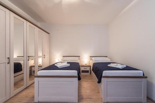 two twin beds in a room with two lamps at Holiday House Lavanda in Vrsi