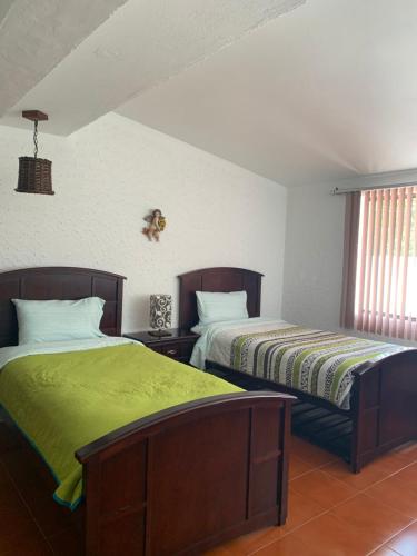 dos camas sentadas una al lado de la otra en un dormitorio en Casa de campo Huasca, en Huasca de Ocampo
