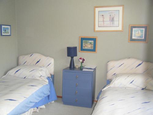 a bedroom with two beds and a night stand with a lamp at TWYNHAM at Kinloch in Kinloch