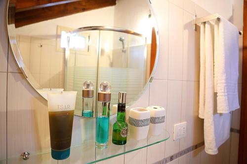 una estantería de cristal en un baño con botellas. en Apartments Athina Orikum, en Orikum
