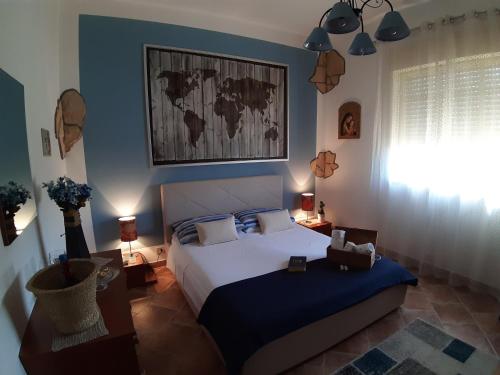 een slaapkamer met een bed met een blauwe muur bij Casa Luce in Caltabellotta