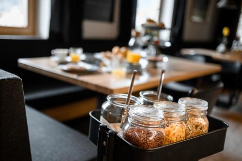 a tray filled with jars of food on a table at Calva B&B Apartments in Malles Venosta