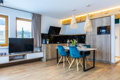 a kitchen with a dining table and blue chairs at Rezydencja Zakopiańska in Zakopane