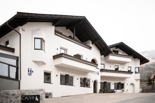 a white building with a black roof at Calva B&B Apartments in Malles Venosta