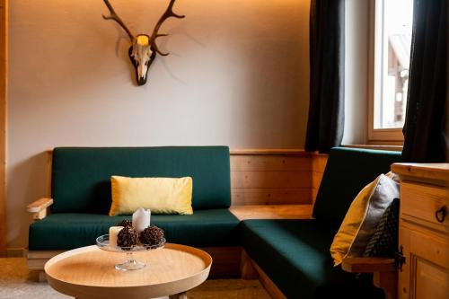a living room with a green couch and a table at Calva B&B Apartments in Malles Venosta