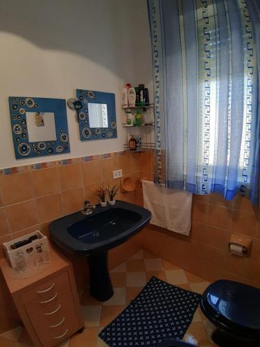 uma casa de banho com um lavatório preto e um WC. em Casa Luce em Caltabellotta