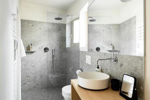 a bathroom with a white sink and a shower at Calva B&B Apartments in Malles Venosta