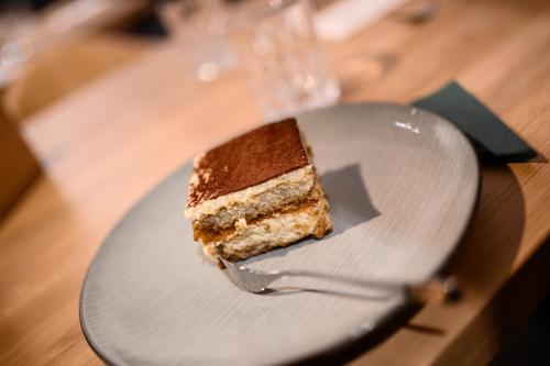 a piece of cake on a plate with a fork at Calva B&B Apartments in Malles Venosta