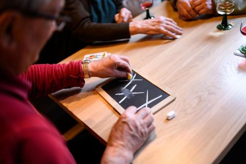an older woman sitting at a table playing a board game at Calva B&B Apartments in Malles Venosta