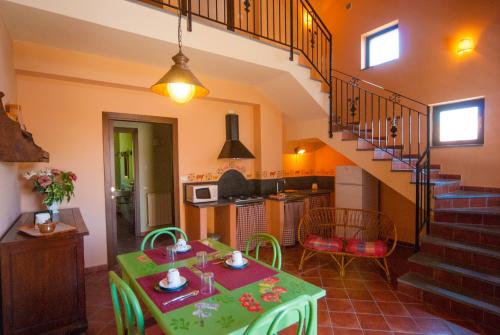 sala de estar con mesa verde y cocina en B&B La Rena Rossa en Nicolosi