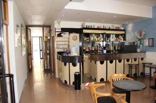 a bar in a restaurant with tables and chairs at Hotel Vela Azzurra in Rimini