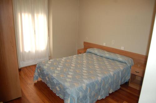 a small bedroom with a bed and a window at Bar Pensión Restaurante Bidasoa in Irún