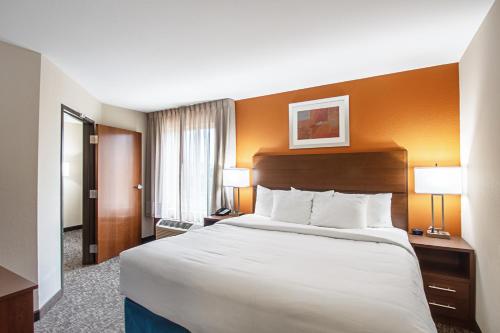 a hotel room with a large bed and two lamps at MainStay Suites Madison - Monona in Madison