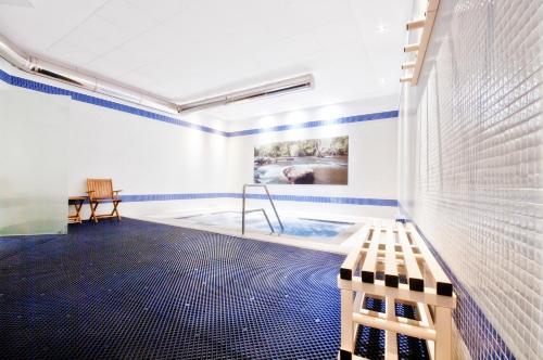a room with a pool with a bench and a painting at Hotel Auditorio Santiago & Spa in Lugo
