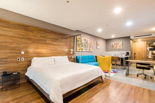 a bedroom with a large bed and a desk at Hotel Spirito by Spiwak Chipichape in Cali