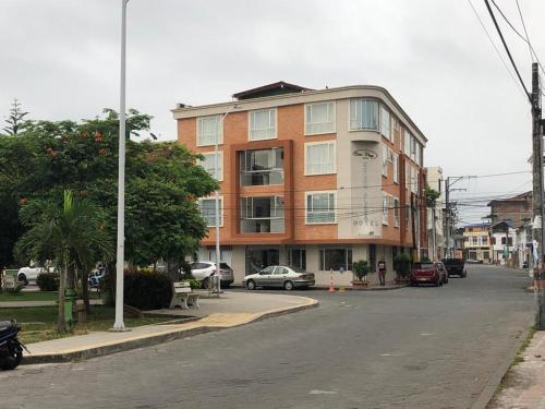 a building on the side of a street with cars at Colon Plaza Hotel in Tumaco