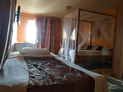 a bedroom with two beds and a canopy bed at Africa 6 Plage in Somone