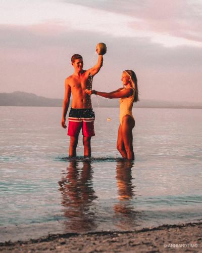 a man and woman standing in the water on the beach at Natura Vista in Panglao