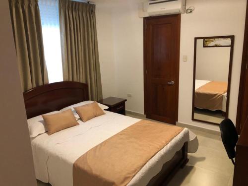 a hotel room with a bed and a mirror at Colon Plaza Hotel in Tumaco
