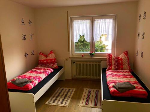 1 dormitorio con 2 camas y ventana en Ferienwohnungen / Ferienhaus Adelsried, en Adelsried