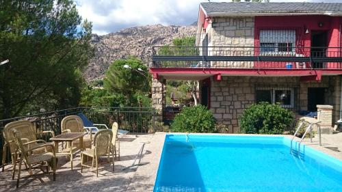 a house with a swimming pool in front of a house at Casa Piedra Libre in Manzanares el Real
