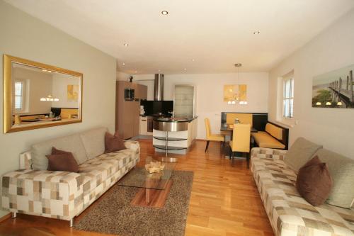 a living room with a couch and a dining room at EXCLUSIVE APARTMENTS - inclusive Zell am See-Kaprun Sommerkarte und unbegrenztem Tauern SPA Eintritt in Kaprun