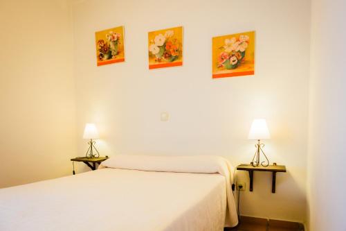 two beds in a room with paintings on the wall at Los Chendas in Villanueva de Ávila