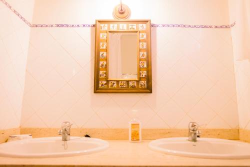 a bathroom with two sinks and a mirror at Los Chendas in Villanueva de Ávila