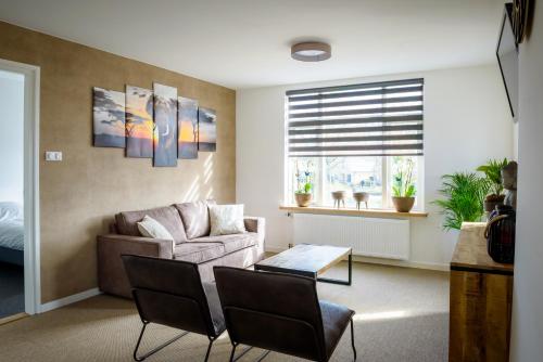 a living room with a couch and a table at Appartement De Witte Brug in Breezand