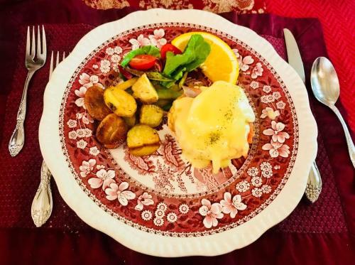 a plate of food with eggs and vegetables on a table at Beaconsfield Bed and Breakfast - Victoria in Victoria