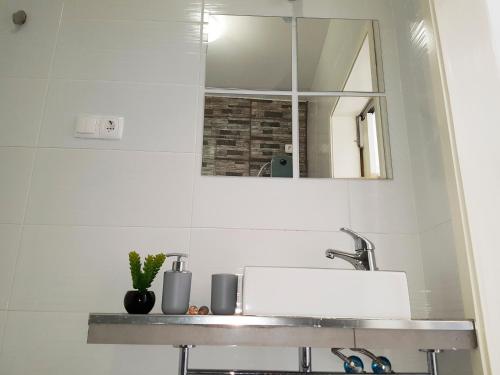 a bathroom with a sink and a mirror at Casa Io - Goraz in Mindelo