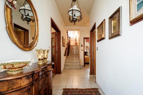 a hallway with a mirror and a wooden dresser at La terrazza del Bimbo in Fucecchio