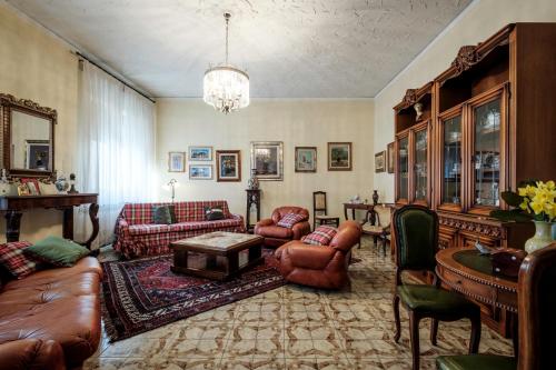 a living room with leather furniture and a chandelier at La terrazza del Bimbo in Fucecchio