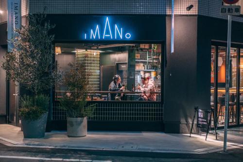 un restaurante mano en una calle de la ciudad por la noche en IMANO OSAKA SHINSAIBASHI HOSTEL en Osaka