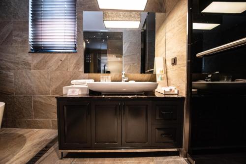 a bathroom with a sink and a mirror at Best Louis Hamilton Hotel Haeundae in Busan