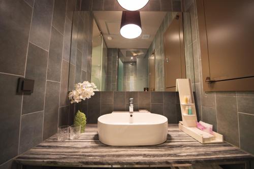 a bathroom with a sink and a large mirror at Best Louis Hamilton Hotel Haeundae in Busan