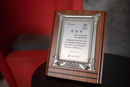 a sign in a wooden frame on top of a table at Best Louis Hamilton Hotel Haeundae in Busan
