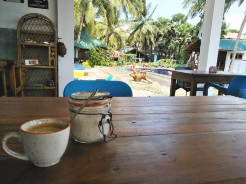 a wooden table with two cups of coffee on it at Bella Nilaveli Beach in Nilaveli
