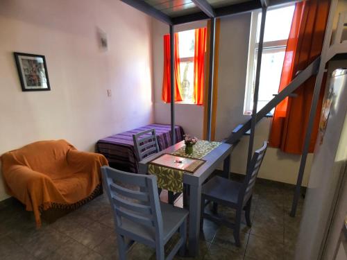 a room with a table and chairs and a staircase at Villa Crespo Arena in Buenos Aires