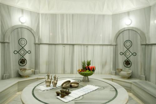 a white room with a table with a bowl of fruit at Grand Cevahir Hotel Convention Center in Istanbul