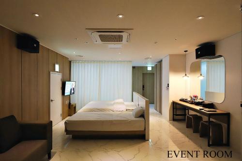 a bedroom with a bed and a desk in a room at Biennale Hotel in Gwangju