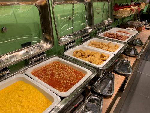 a buffet line with different types of food in trays at Henn na Hotel Tokyo Haneda in Tokyo