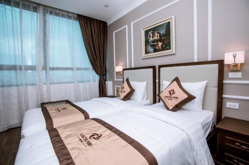 two beds sitting next to each other in a hotel room at Louisland Hanoi Hotel in Hanoi