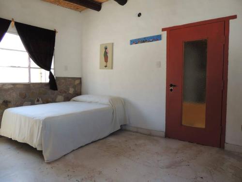 Schlafzimmer mit einem Bett und einer roten Tür in der Unterkunft Lo de Joaquin in Tilcara