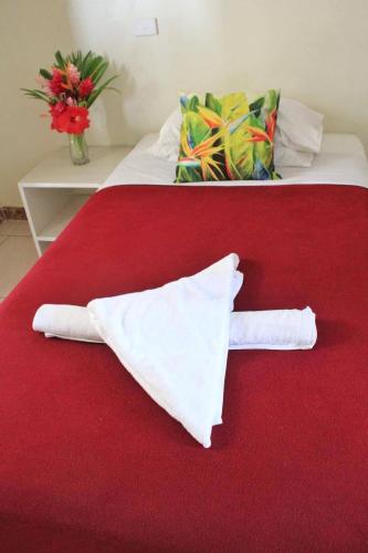 a red bed with two white towels on it at Pacific Paradise Motel in Port Vila