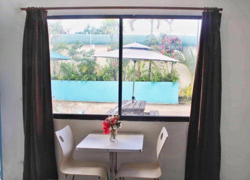 una mesa con un jarrón de flores encima de una ventana en Pacific Paradise Motel en Port Vila