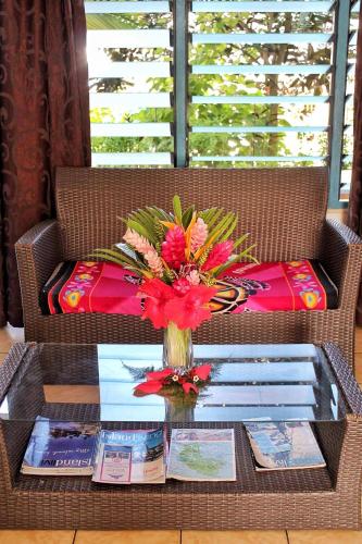 a table with a vase of flowers on a table at Pacific Paradise Motel in Port Vila