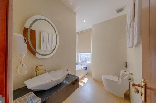 a bathroom with a sink and a toilet and a mirror at SEA QUEEN Hotel in Danang